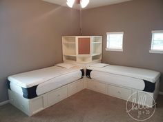 a bedroom with two twin beds and a bookcase in the corner on the wall