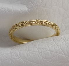 a gold wedding ring sitting on top of a white cloth