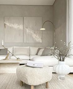 a living room filled with white furniture and decor