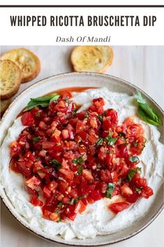 a bowl filled with mashed potatoes and garnished with tomato relish next to slices of bread