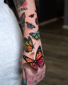 a woman's arm with colorful butterflies on it