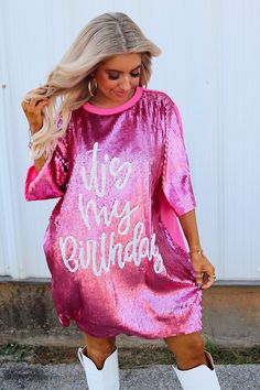 Dress features a scoop neckline, short sleeves, front sequins with a "It's My Birthday" design, t-shirt back, lined, and a loose fit. 100% Polyester Hand wash cold. Do not bleach. Hang dry. No iron. Kaitlyn is 4’11” wearing a ONE SIZE Birthday Sequin Dress, It's My Birthday, Rose Boutique, Birthday Design, Design T Shirt, Its My Birthday, My Birthday, Sequin Dress, Scoop Neckline