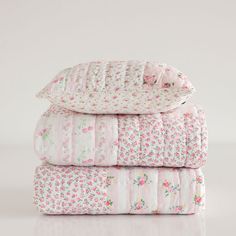 three sheets stacked on top of each other in pink and white floral print with ruffled edges