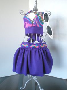 "Two piece purple bikini. Top ties at the neck and velcros at the chest. Bikini top made out of a whimsical rainbow color lycra...just beautiful!. Ruffle bottom skirt adorn with a braided cord at the waist. Skirt velcros at the waist. Made out of swim wear material. SPECIAL SET PRICE: for set of bathing suit, hat and towel. To order the set look under our \" \"BATHING SUIT 3 PIECE SET\" (3 PIECE SET\" Hat and towel come with matching accents) SIZES: XXSm XSM XS?SM SM SM/M MED MED/LRG LRG L/XL XL Playful Purple Swimwear For Swimming, Playful Festival Swimwear, Playful Purple Fitted Swimwear, Playful Fitted Purple Swimwear, Adjustable Purple Swimwear For Swimming, Playful Swimwear For Festivals, Playful Fitted Swimwear For Festivals, Adjustable Purple Swimwear For Summer, Blue Rave Swimwear For Summer