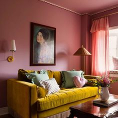 a living room filled with furniture and a painting hanging on the wall above a coffee table