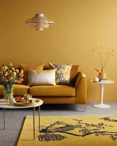 a living room filled with furniture and flowers in vases on top of a table