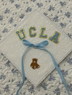 a graduation cap with a teddy bear on it and the word u c l a