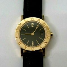 NICE BVLGARI LADIES DATE WATCH, BLACK FACE, 18K GOLD, BLACK BULGARI LEATHER BAND, BB 26 GL 26mm. 18 k gold Bvlgari BUCKLE. Case Size: 26mm. Bezel: 18k gold. Buckle Specifications. Watch Specifications. Yellow Gold Analog Watch With Round Dial, Formal Yellow Gold Analog Watches And Jewelry, Formal Yellow Gold Analog Jewelry And Watches, Luxury Gold Watches Stamped 14k, Designer Gold Watch For Anniversary, Luxury Gold Watches, Bvlgari Watch, Bulgari Watch, Leather Band