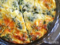 a close up of a pizza on a pan with cheese and spinach toppings