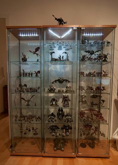 a display case filled with lots of different types of figurines on glass shelves