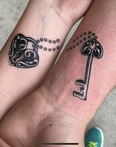 two people with matching tattoos on their arms and feet, one has a key to the other