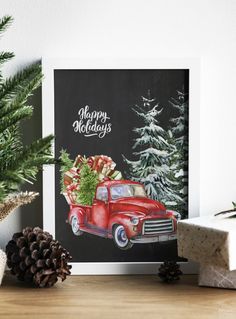 a christmas card with an old red truck carrying presents and pine cones on the table