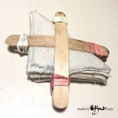 a cross made out of cloth with a wooden stick sticking out of it's side