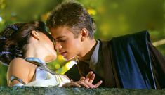 a young man and woman are kissing each other in front of a green background with trees