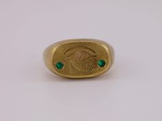 The iconic symbol of the Eye of Horus, revered for its protective powers, is boldly engraved on the cushion signet face. Flanking the eye are two brilliant lab-grown emeralds, reminiscent of the lush beauty of ancient Egypt. This ring is a masterful blend of historic symbolism and modern sophistication, designed with an aged brush finish 22k gold vermeil. Made in solid sterling silver, this ring is a weighty piece. Discover a piece that connects the mystic past with the brilliant present. This piece is made to order, so please allow approximately 3 weeks for the craftsmanship required. Alternative stone options available - please reach out for more info. Instagram - @caeliajewellery Website - www.caeliajewellery.com/ The Eye Of Horus, The Mystic, Eye Of Horus, Pearl Gemstone, Black Rhodium, Raw Gemstones, Jewelry Rings Engagement, 22k Gold, Ancient Egypt