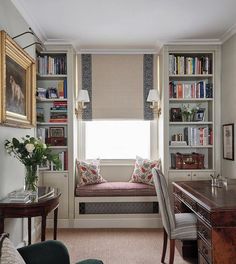 a living room filled with furniture and bookshelves next to a window covered in curtains