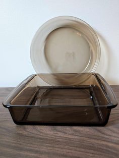 an empty glass dish and plate on a wooden table