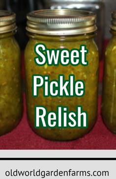 three jars filled with pickle relish sitting on top of a red table cloth