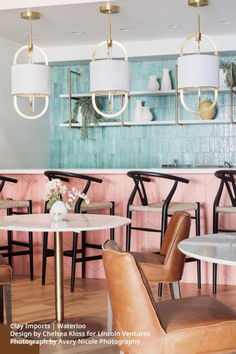 the interior of a restaurant with chairs, tables and vases on the wall behind them