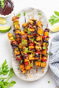 skewered chicken and vegetable kabobs on a plate with cilantro sauce