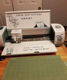 a cricut machine sitting on top of a wooden table next to a cutting board