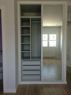 an empty room with white walls and open closets in the center, along with hardwood floors