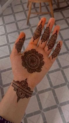 a person's hand with henna tattoos on it