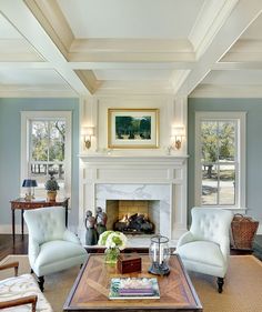 a living room filled with furniture and a fire place under a painting on the wall