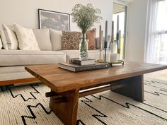 a living room with a couch, coffee table and books on top of the table