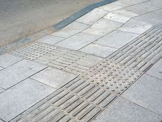 a manhole cover on the side of a road with grate holes in it