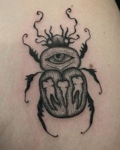 a beetle with an eye on it's back tattoo by the talented artist in progress