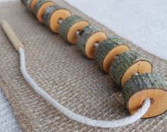 a close up of a piece of cloth with yarn on it and wooden beads in the middle