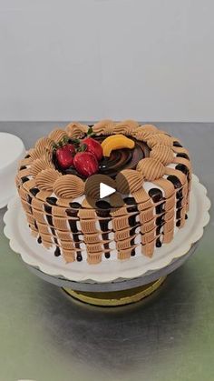 a cake sitting on top of a table next to a plate with fruit and chocolate