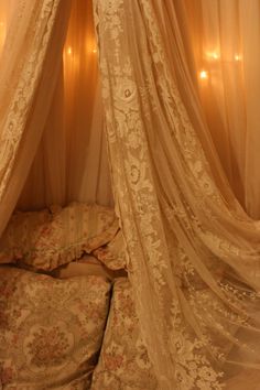 the canopy bed is made up with sheer curtains and flowers on it's headboard