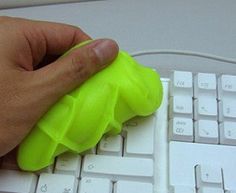 a person's hand is on top of a computer keyboard with a green rubber band around it