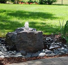 a rock in the middle of a garden