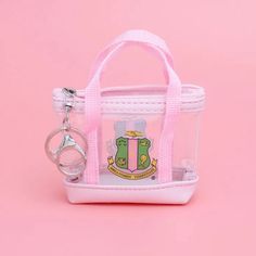 Showcase Your Alpha Kappa Alpha Pride With Our Charming Wholesale Aka Sorority Mini Tote Zipper Pouch Keychain Clip. This Stylish Accessory Features A Clear Pvc Mini Tote Bag-Shaped Zipper Pouch With Sturdy Canvas Straps, Adorned With A Vibrant Pink And Green Aka Shield Graphic Print On Both Sides. Perfectly Sized For Your Airpods, This Pouch Comes With A Silver Metal Keychain Ring And Handbag Clip For Added Convenience. Carry Your Essentials With A Touch Of Sorority Elegance. Charming Features Sorority Paraphernalia, Alpha Kappa Alpha Sorority Paraphernalia, Sorority Row, Pouch Keychain, Aka Sorority, Keychain Ring, Keychain Clip, Practical Fashion, Alpha Kappa Alpha