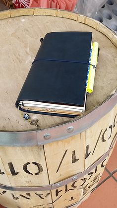 a notebook sitting on top of a wooden barrel