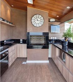 a large clock mounted to the side of a wall above a stove top oven in a kitchen