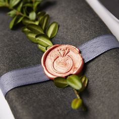 a wax seal with a rose on it sitting on top of a piece of cloth