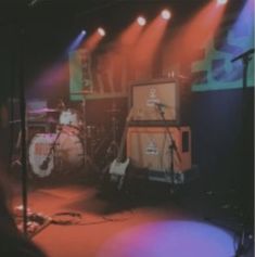 the stage is lit up with red and blue lights as well as music equipment on it