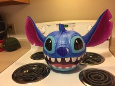 an odd looking mask sitting on top of a stove