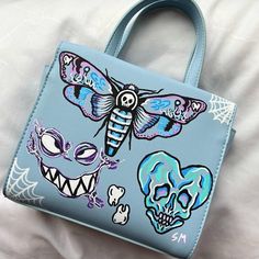 This is a one-of-a-kind, custom purse drawn on by me with posca paint pens! #art #artist #fashion #diy #artwork #spooky #creative #egirl #alt #skull #moth #drawing #painting Custom Purses Paint, Painted Purses Ideas Diy, Painted Bag Ideas, Posca Clothes, Drawings On Bags, Purse Painting Ideas