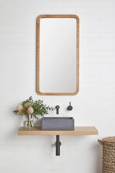 a bathroom sink with a wooden mirror above it