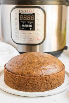 a cake on a plate next to an instant pot