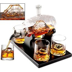 an image of whiskey being poured into glasses on top of a black tray with two shot glasses