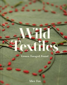 the cover of wild textiles, with red berries on green leafy branches in the background