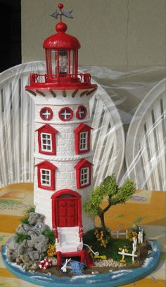 a red and white lighthouse on top of a table