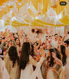 a group of people standing around each other in front of a ceiling full of lights