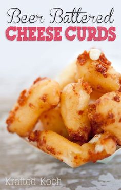 a close up of some food in a paper container with the words beer battered cheese curls on it